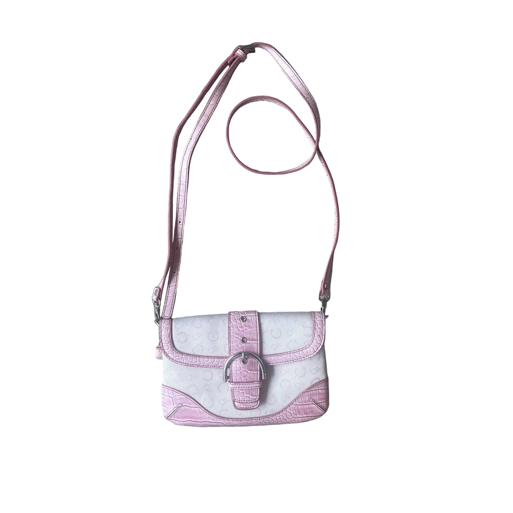 A pink and white faux-croc crossbody bag with a silver buckle and a matching pink strap, laid flat on a gray wood-look floor.