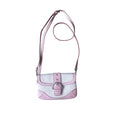 A pink and white faux-croc crossbody bag with a silver buckle and a matching pink strap, laid flat on a gray wood-look floor.